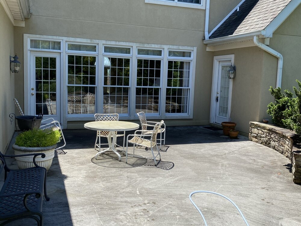 Dirty stained concrete patio before pressure washing
