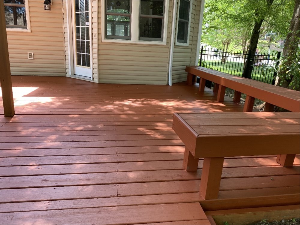 Same wood deck restored to a warm reddish-brown color after staining