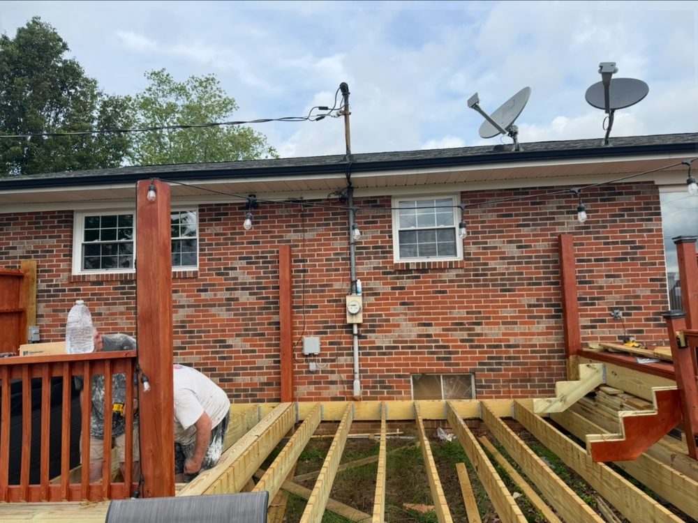 New deck joists installed on correct spacing behind a brick home