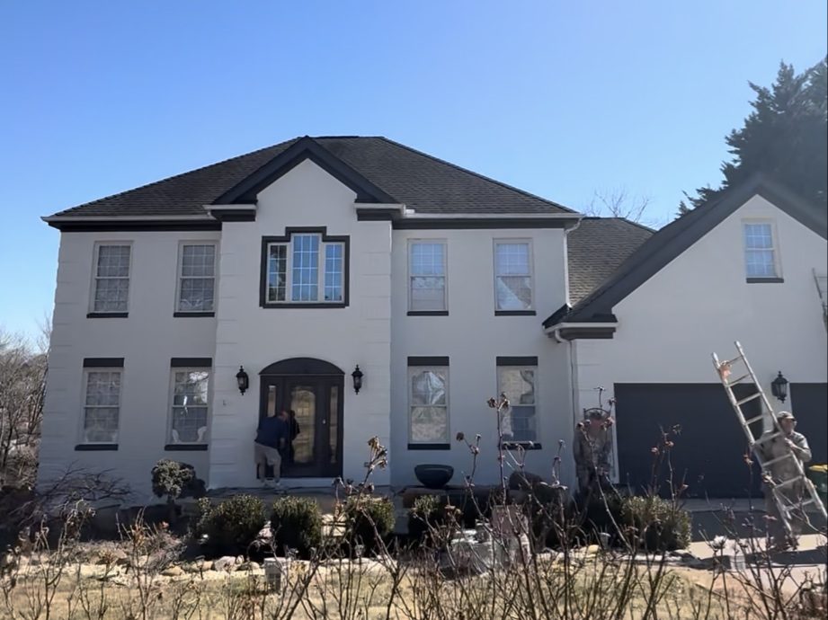 Two-story home after a full exterior repaint in white with black trim