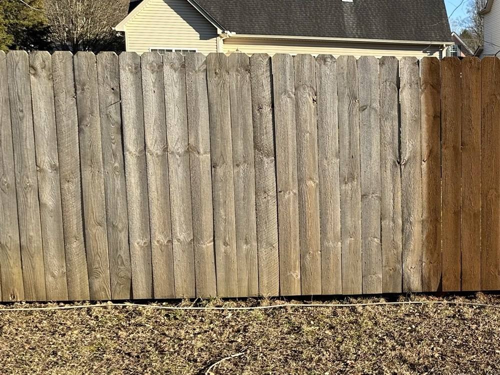 Gray, weathered wood privacy fence before staining