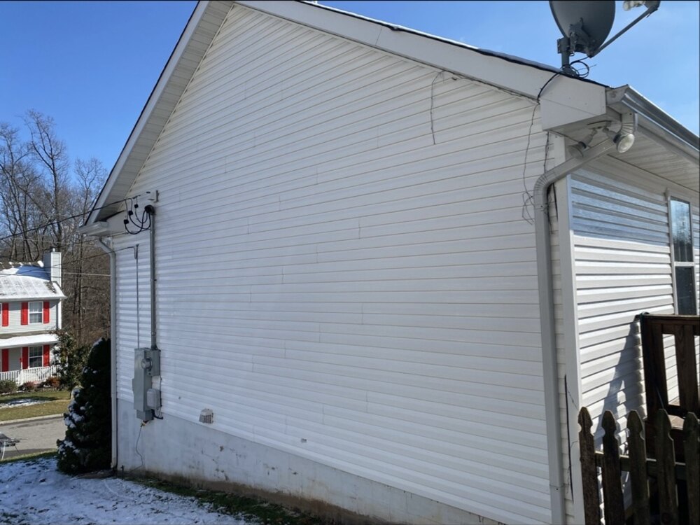 Same vinyl siding restored to bright white after professional house washing